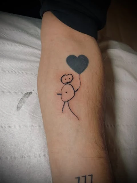 Petit personnage & cœur : tatouage réalisé par Lady Ness à Annecy