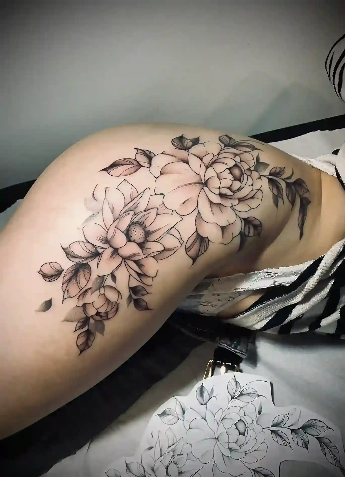 Tatouage floral avec fleurs et feuillages sur une épaule